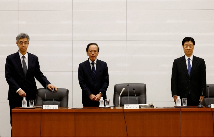 کازوئو اوئدا، رئیس بانک ژاپن (مرکز) و معاونان دولت. ریوزو هیمینو (چپ) و شینیچی اوچیدا (راست) در یک کنفرانس خبری در دفتر مرکزی بانک در توکیو در آوریل 2023 شرکت کردند.